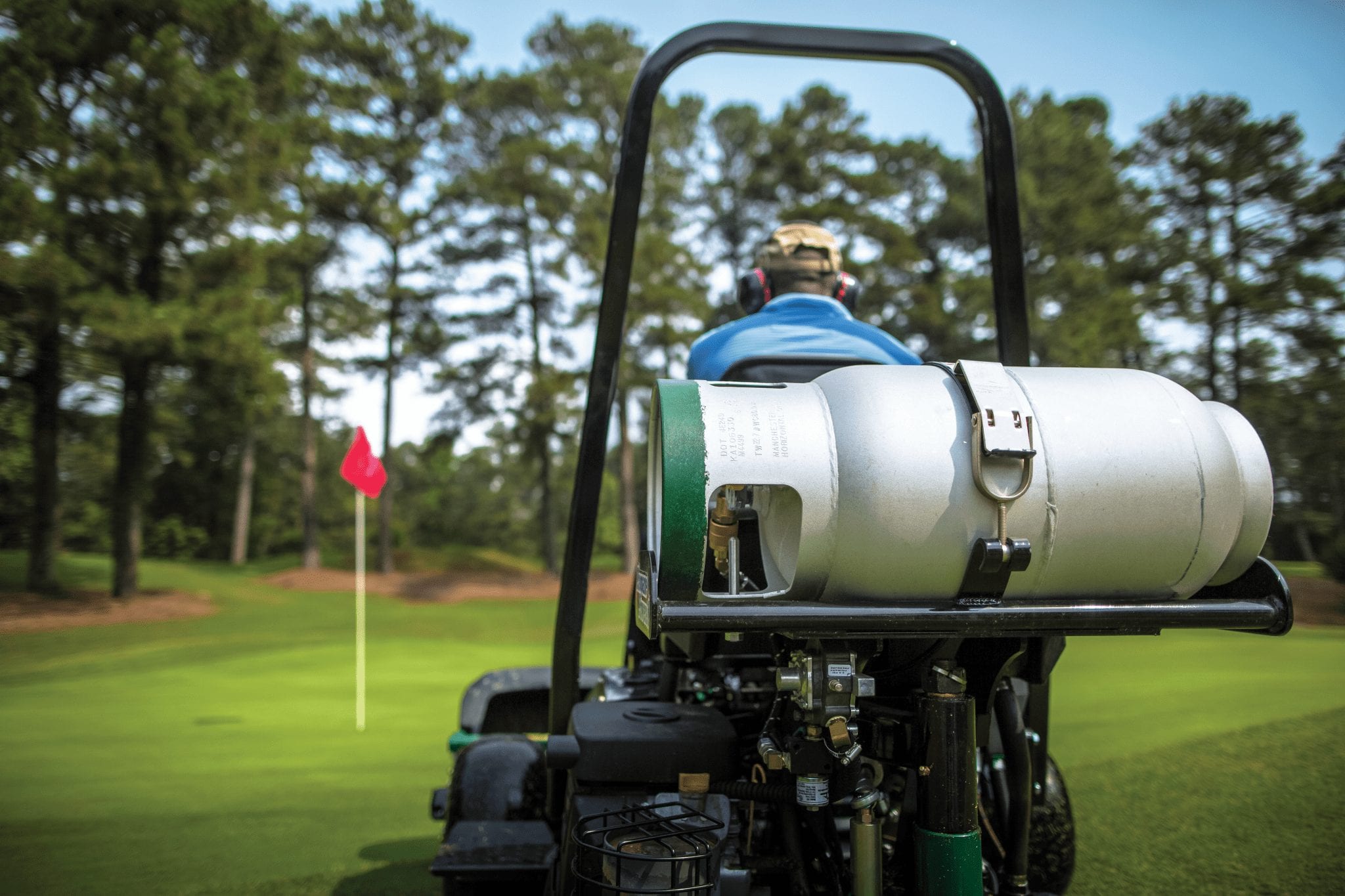 man mowing golf course with propane powered lawn mower